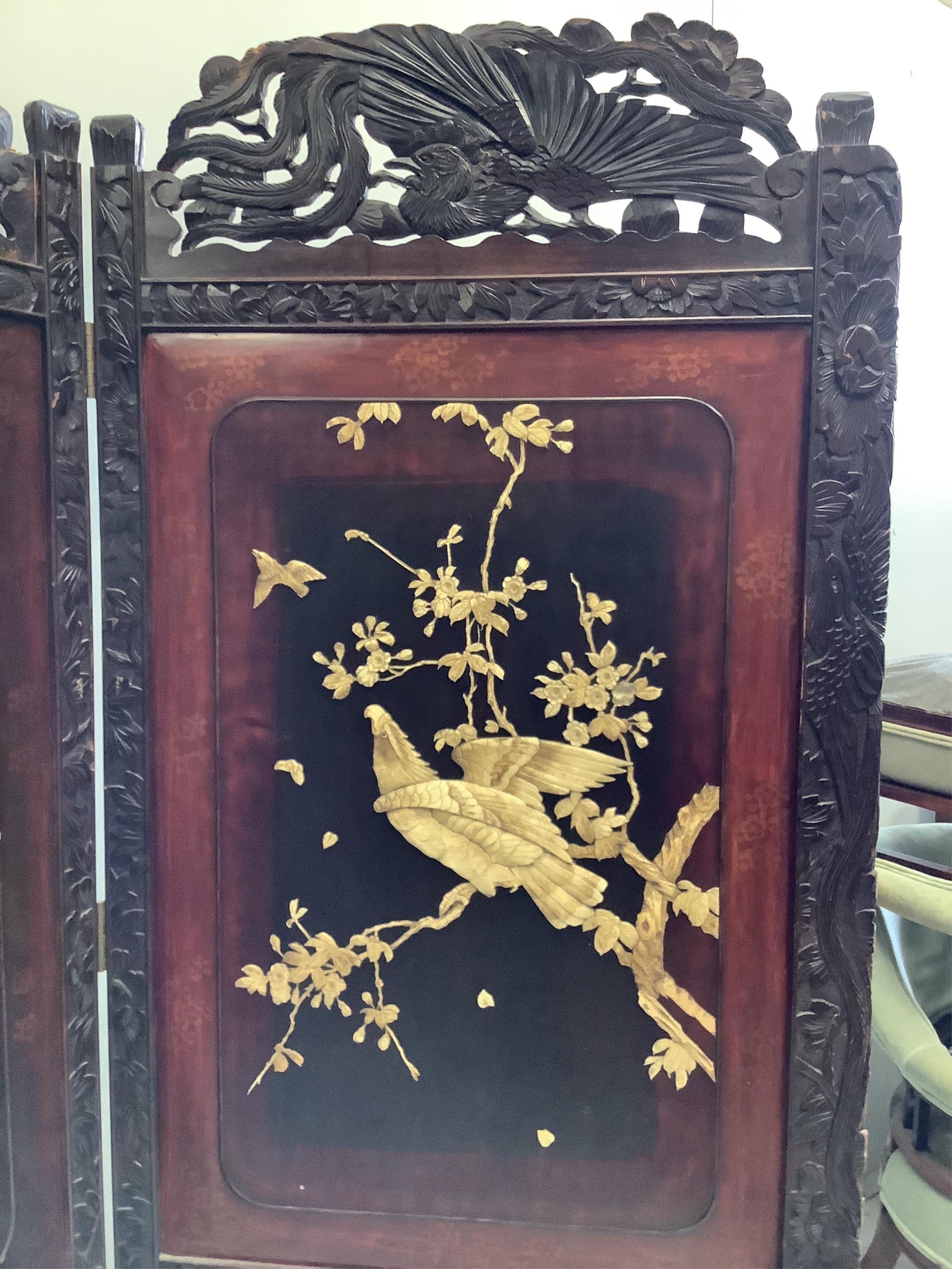 A Japanese carved wood bi-fold screen inset with lacquer and bone ‘eagle’ panels, each panel, width 79cm, height 180cm. Condition - fair